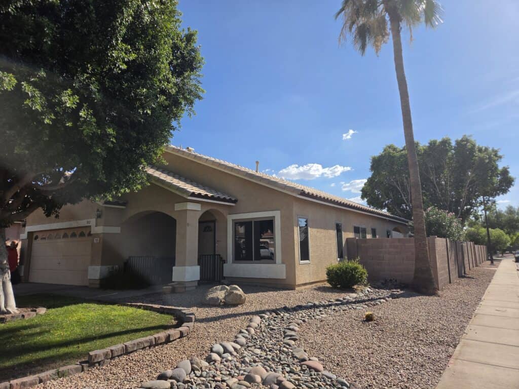 Single-story residential home with a tile roof and desert landscaping.